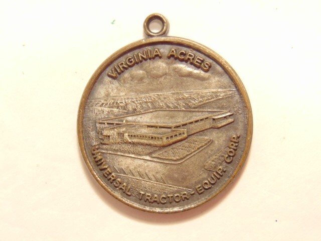 Universal Tractor Equipment Corp. 10th anniversary 1963 silver colored pendant
