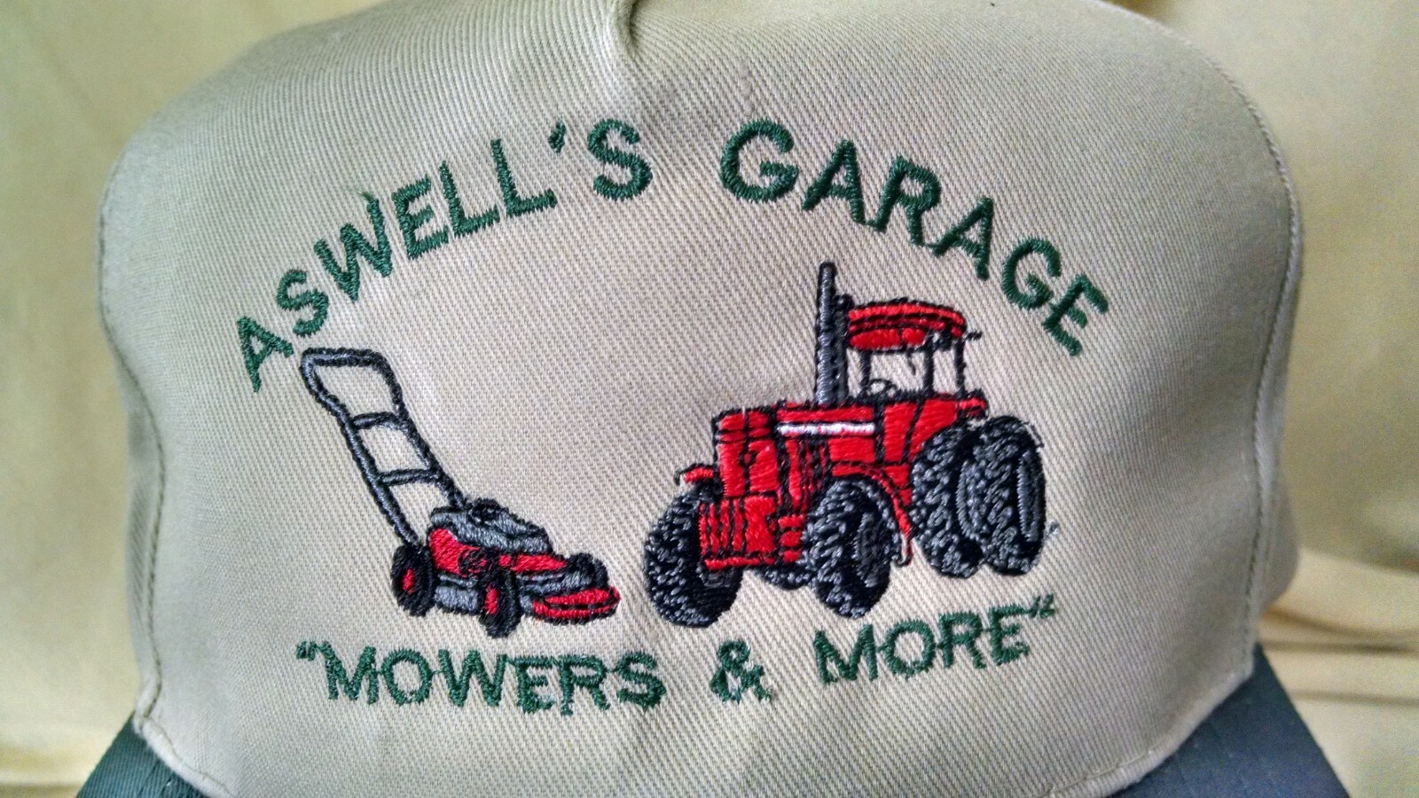 ASWELL&rsquo;S GARAGE HAT MOWERS & MORE GRASS CUTTER TRACTOR BEIGE GREEN OTTO ADJBL.