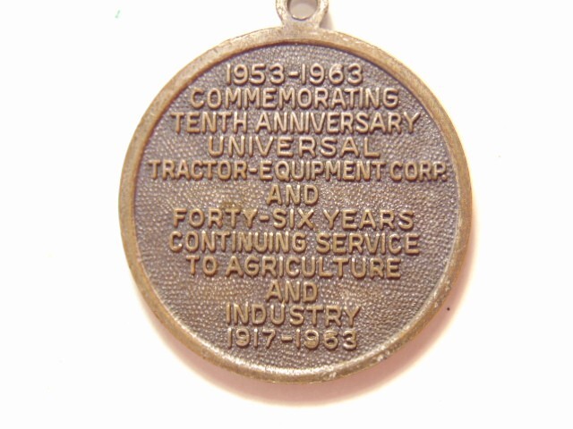 Universal Tractor Equipment Corp. 10th anniversary 1963 silver colored pendant